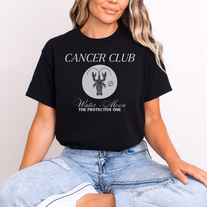 Black t-shirt with a Cancer zodiac-themed design labeled 'Cancer Club.' The center features a gray lobster illustration with the words 'Water - Moon' and 'The Protective One' beneath, symbolizing the Cancer zodiac sign with its water element and association with the moon.