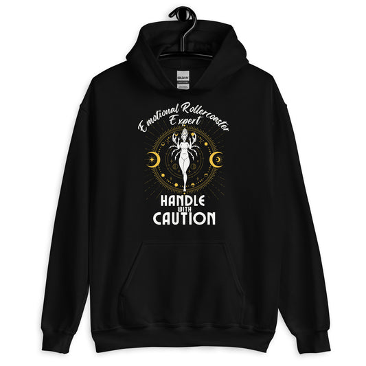 Black hoodie featuring a Cancer zodiac-themed design with the phrase 'Emotional Rollercoaster Expert' at the top and 'Handle With Caution' at the bottom. The central illustration depicts a stylized figure surrounded by celestial symbols, including moons and stars, with a mystical, radiant backdrop in yellow accents.