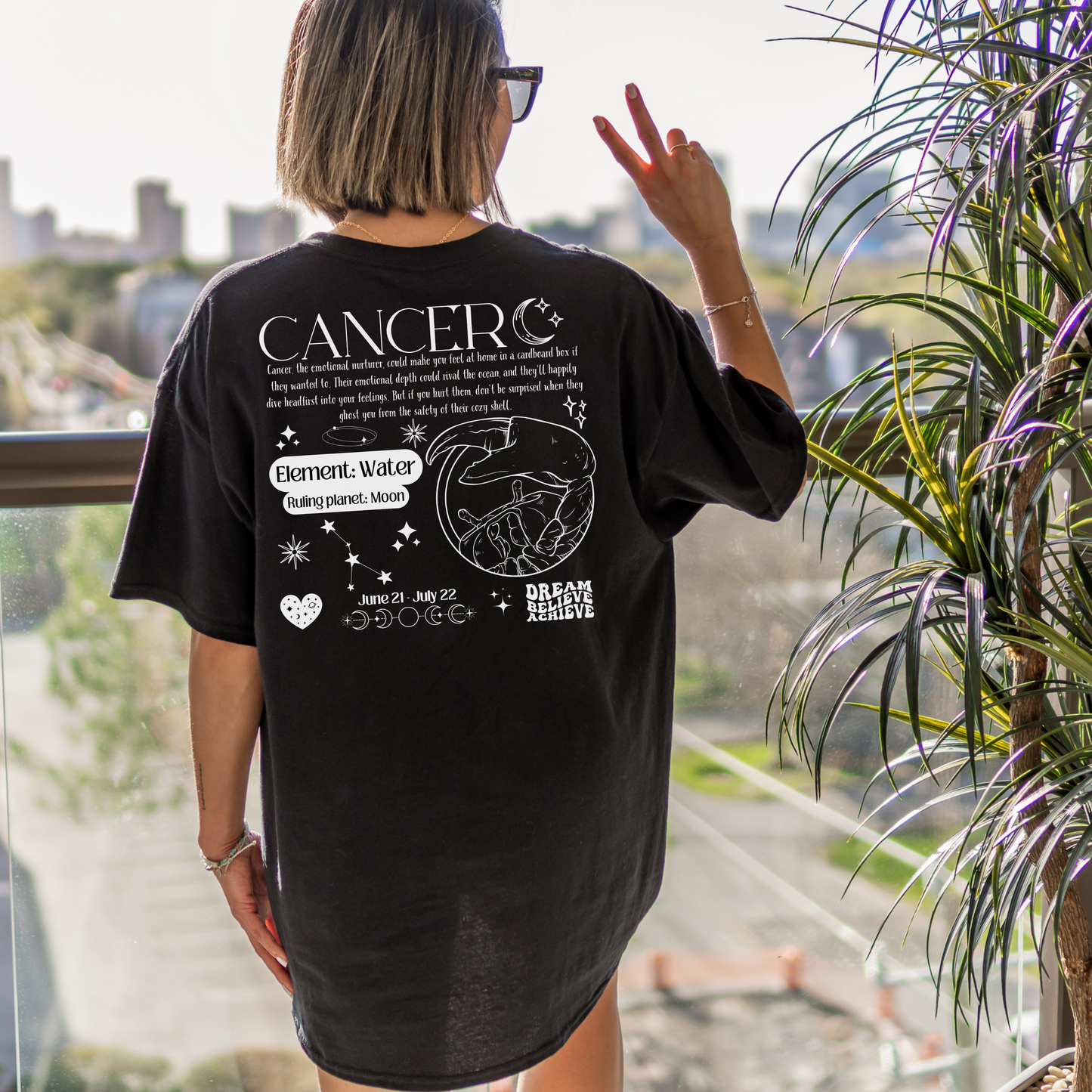 Back of black Cancer-themed t-shirt featuring retro zodiac design with traits, Cancer symbol, element Water, and ruling planet Moon.