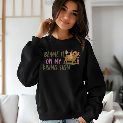 Black sweatshirt with 'Blame It On My Rising Sign' text and colorful Aries design.