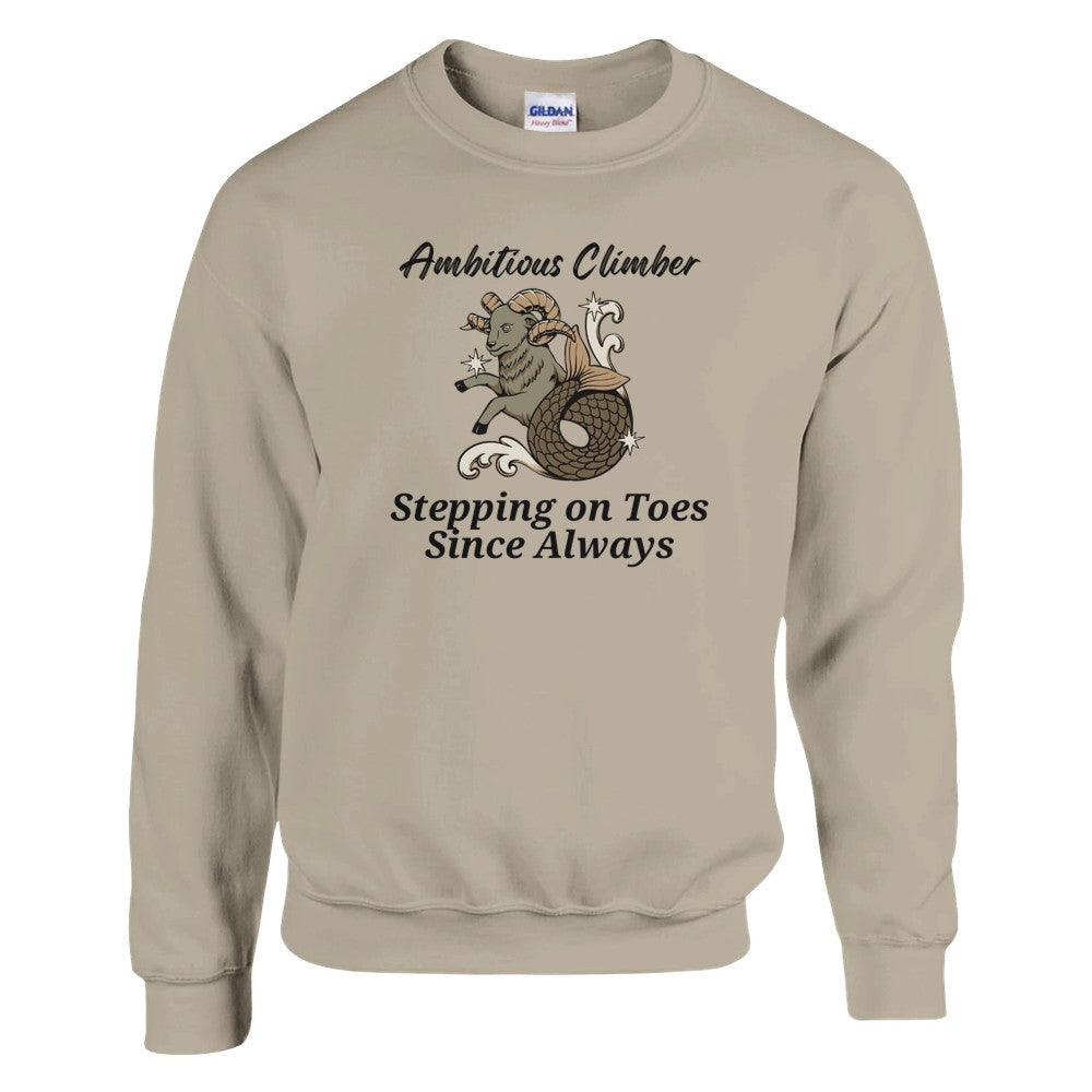 Front of sand Capricorn-themed sweatshirt with a playful design featuring a Capricorn goat character and the text 'Ambitious Climber - Stepping on Toes Since Always.