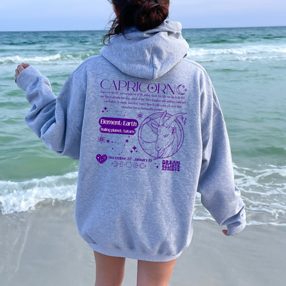 Back of sport grey Capricorn-themed hoodie featuring retro astrology design with Capricorn symbol, element Earth, ruling planet Saturn, and decorative celestial details.