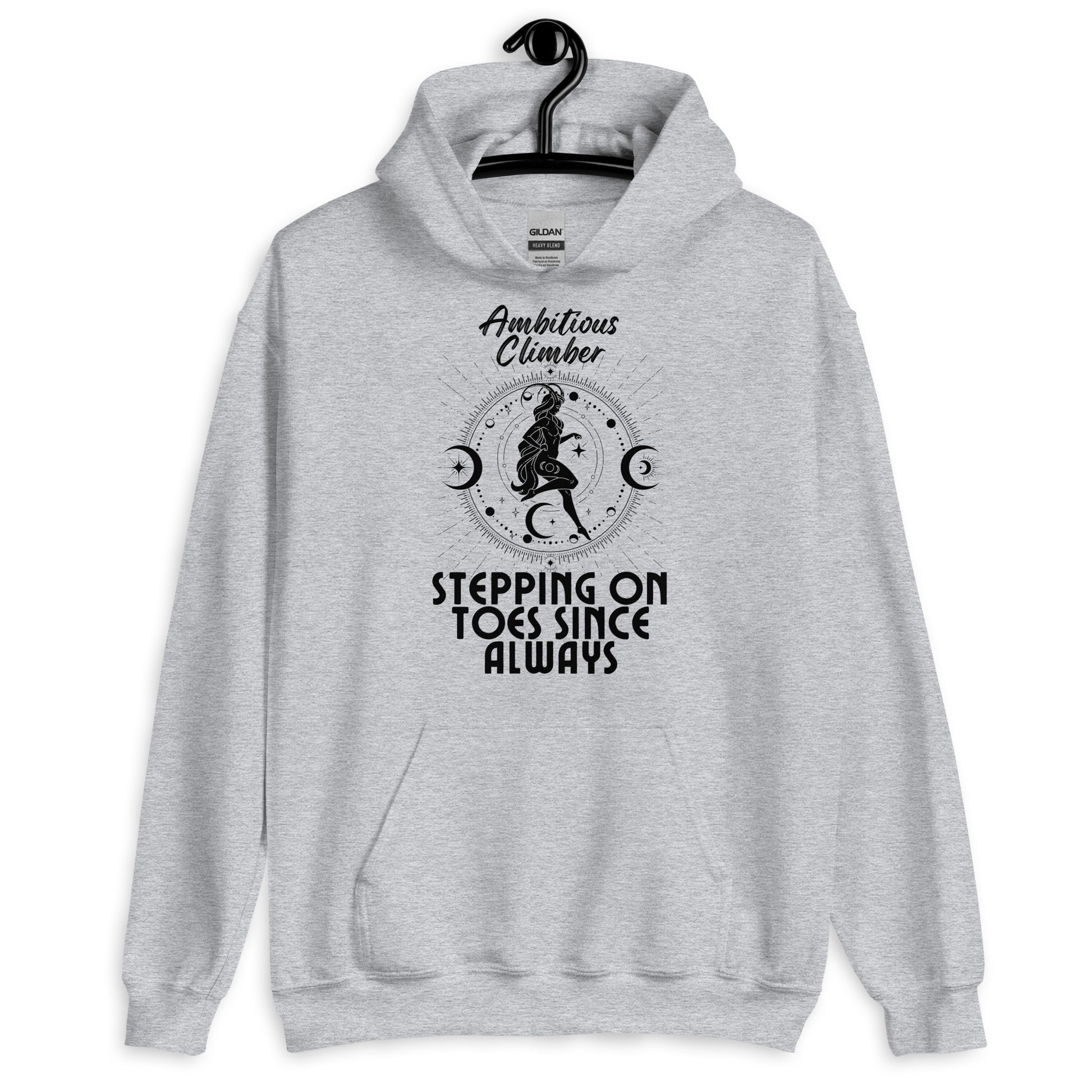 Front of sport grey Capricorn-themed hoodie with retro design, featuring text 'Ambitious Climber' above an illustration of a determined figure, surrounded by celestial symbols, and 'Stepping on Toes Since Always' below.