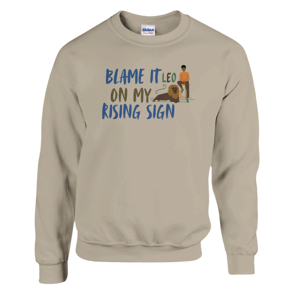 Front of sand sweatshirt with Leo-themed design, text 'Blame It On My Rising Sign' featuring a person and a lion illustration.