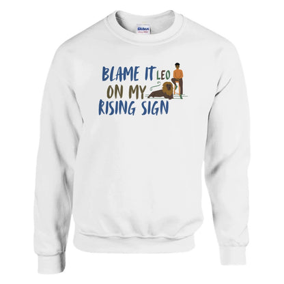 Front of white sweatshirt with Leo-themed design, text 'Blame It On My Rising Sign' featuring a person and a lion illustration.