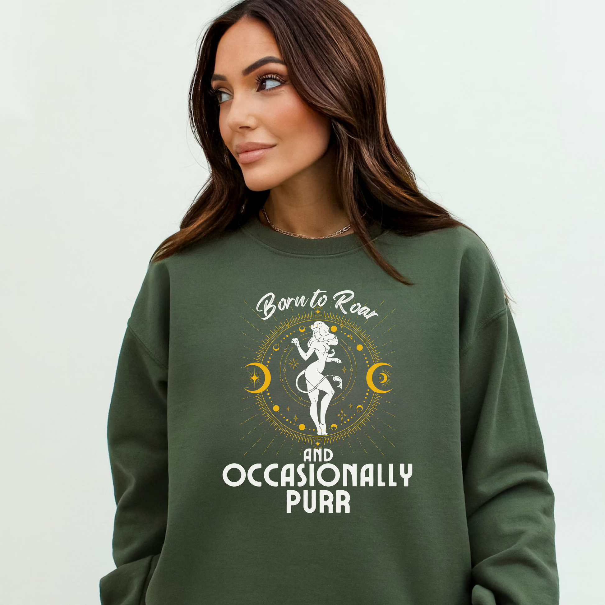 Front of military green sweatshirt featuring a Leo-themed design with a celestial motif around a lion figure in white and yellow accents. Text reads 'Born to Roar and Occasionally Purr.