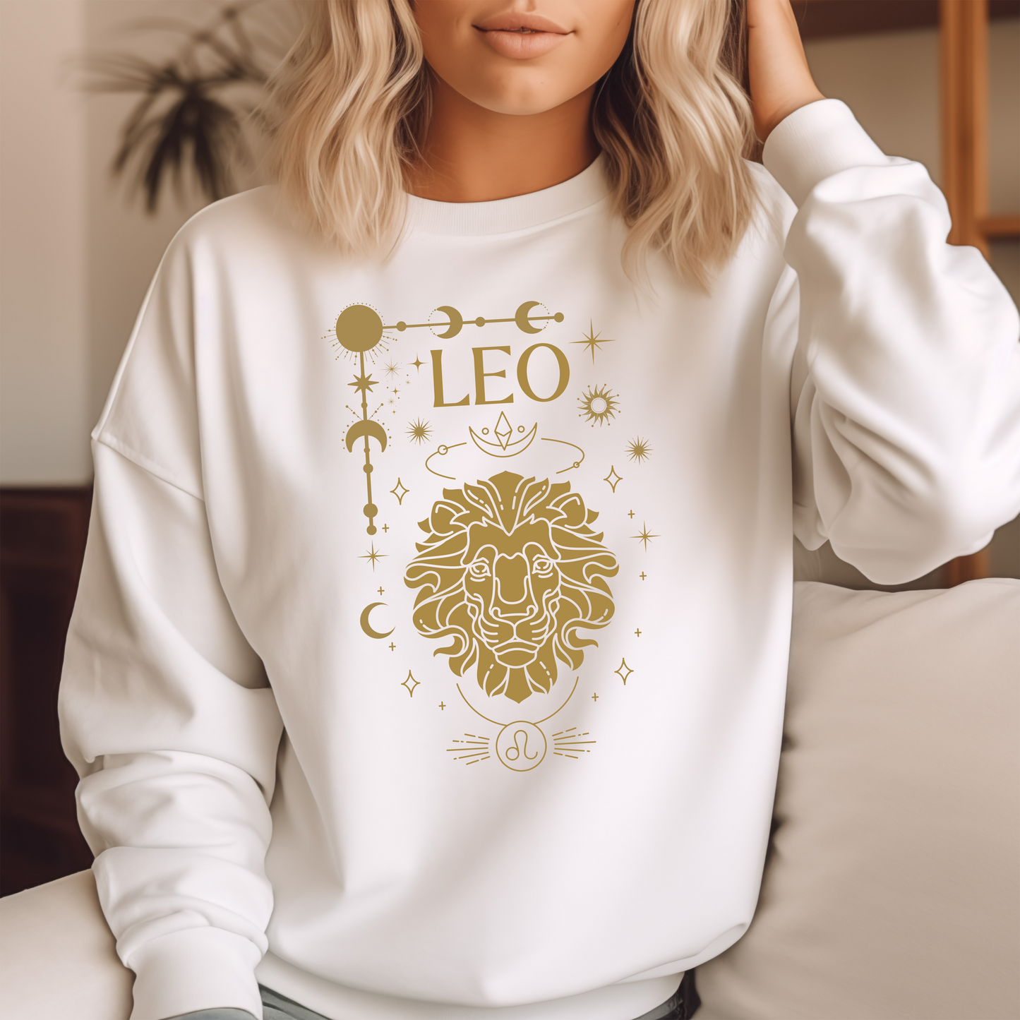 Front of white sweatshirt featuring a Leo-themed glamour design with a stylized brown lion illustration and celestial symbols. Text reads 'Leo' with zodiac symbol.