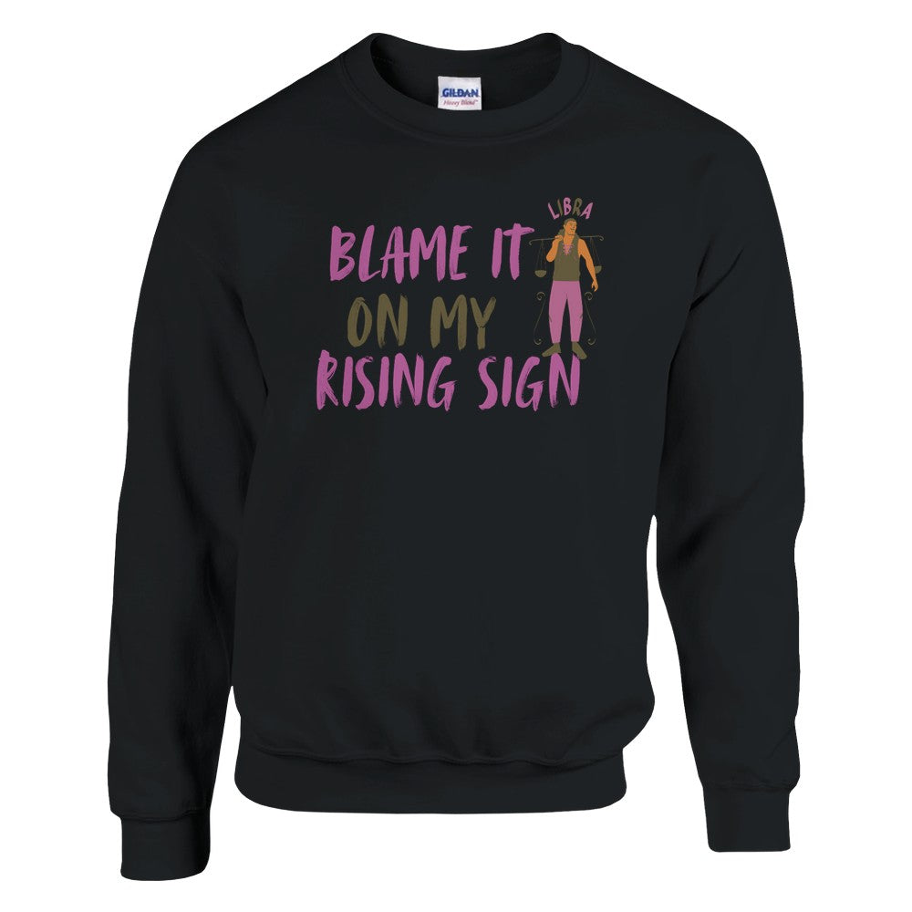 Front of black Libra sweatshirt with 'Blame It on My Rising Sign' text and illustration featuring a balanced scale symbol.