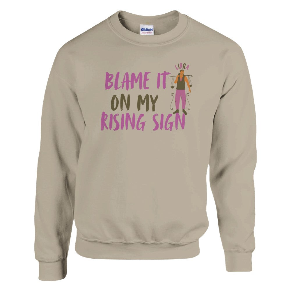 Front of sand Libra sweatshirt with 'Blame It on My Rising Sign' text and illustration featuring a balanced scale symbol.