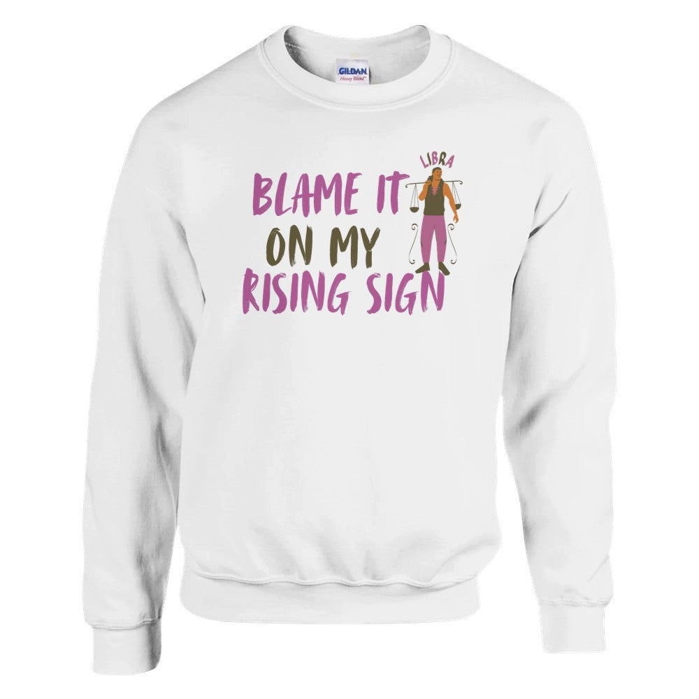 Front of white Libra sweatshirt with 'Blame It on My Rising Sign' text and illustration featuring a balanced scale symbol.