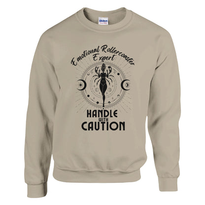 Sand cancer zodiac sweatshirt with 'Emotional Rollercoaster Expert' and 'Handle with Caution' text; design features Cancer symbol with celestial elements, showcasing a playful take on Cancer traits.