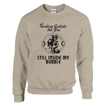 Sand sweatshirt with 'Thinking Outside the Box, Still Inside My Bubble' text and black celestial-themed illustration.