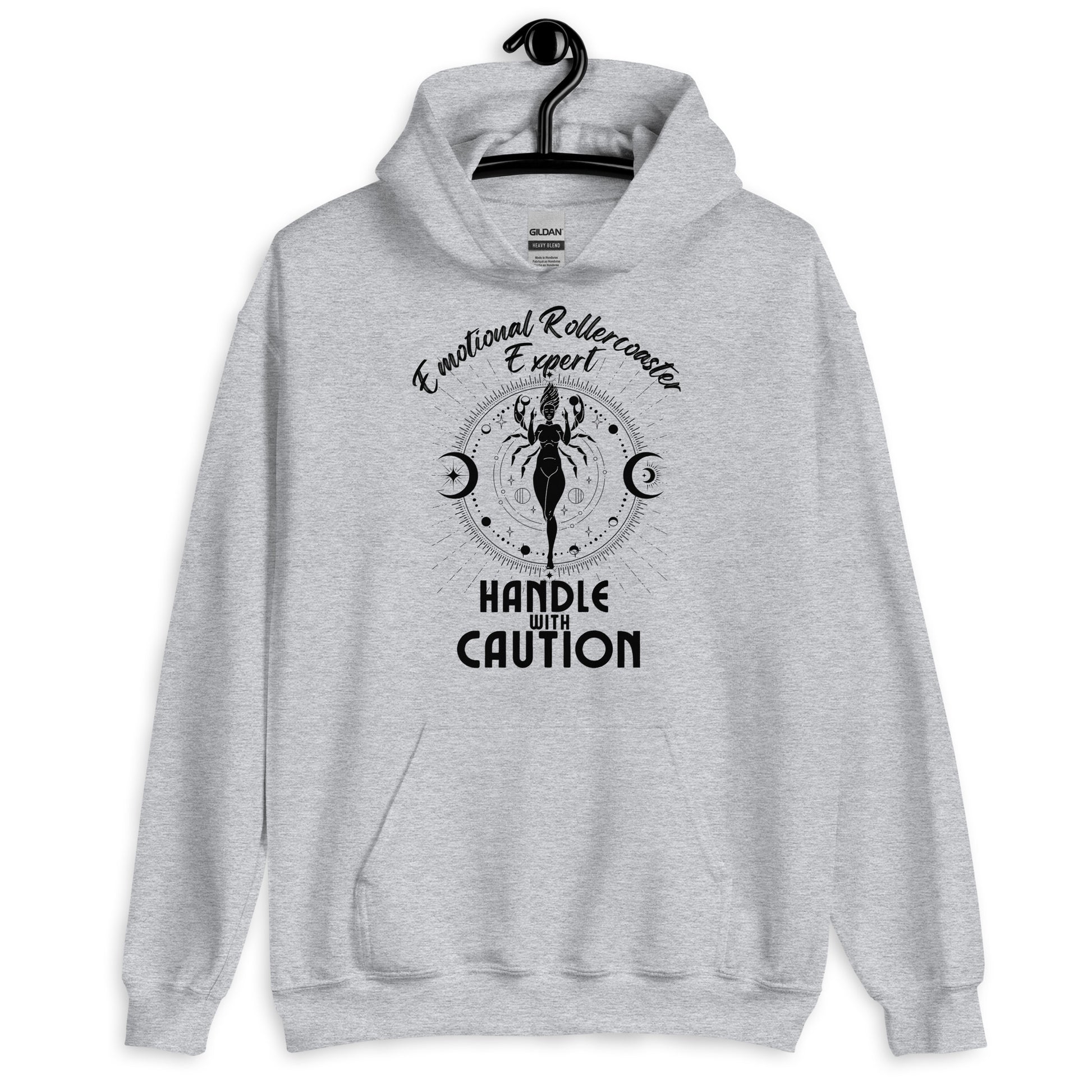 Sport grey hoodie featuring a Cancer zodiac-themed design with the phrase 'Emotional Rollercoaster Expert' at the top and 'Handle With Caution' at the bottom. The central illustration depicts a stylized figure surrounded by celestial symbols, including moons and stars, with a mystical, radiant backdrop in black accents.