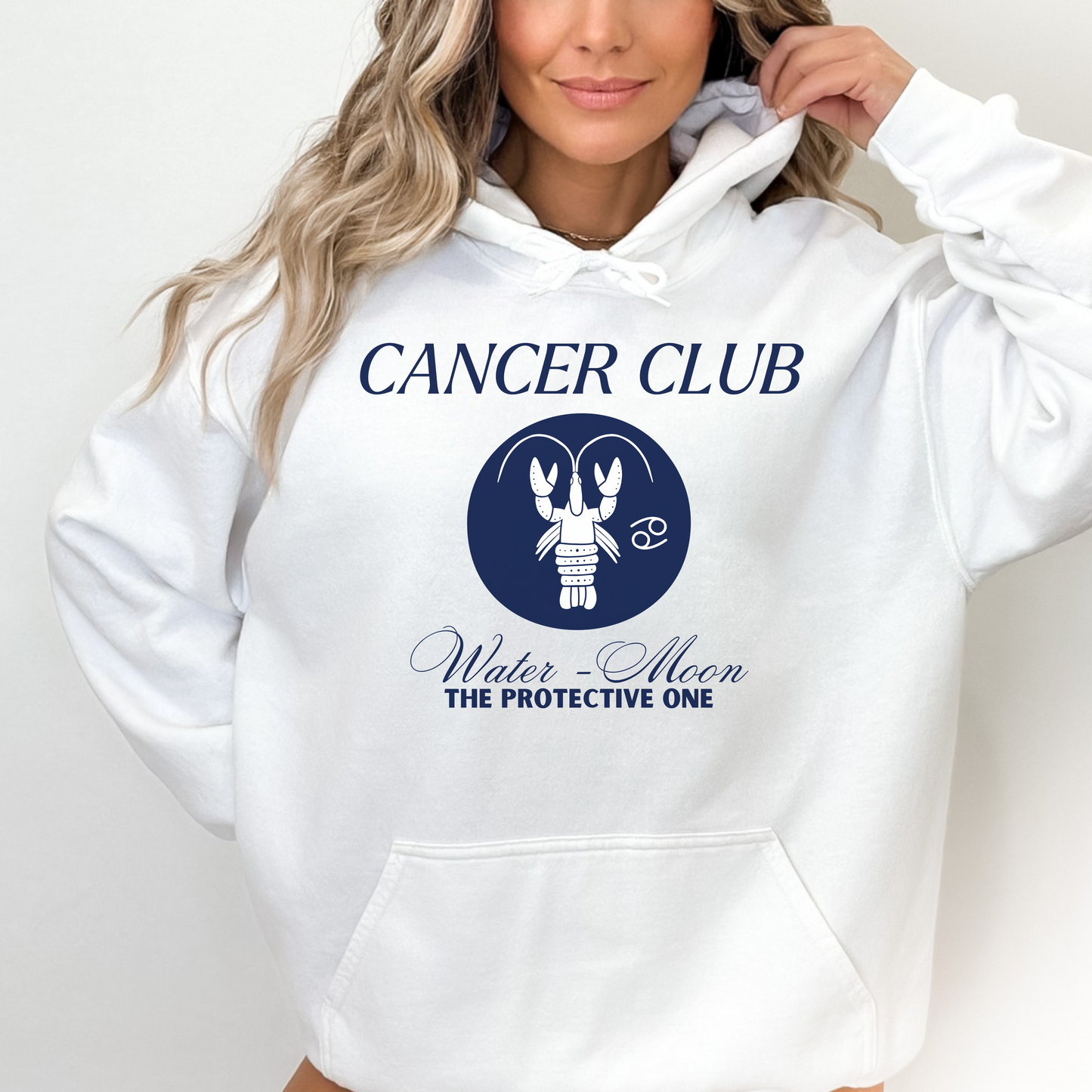 White hoodie with a 'Cancer Club' design featuring a blue, minimalist depiction of a lobster in a circular emblem. Text below reads 'Water - Moon' and 'The Protective One,' emphasizing Cancer's astrological traits. The hoodie has a casual and modern design, ideal for those identifying with the Cancer zodiac sign.