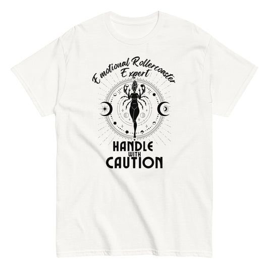 White t-shirt featuring a Cancer zodiac-themed design with the phrase 'Emotional Rollercoaster Expert' at the top and 'Handle With Caution' at the bottom. The central illustration displays a stylized figure in a mystical design surrounded by celestial symbols, including moons, against a radiant, detailed backdrop in black.