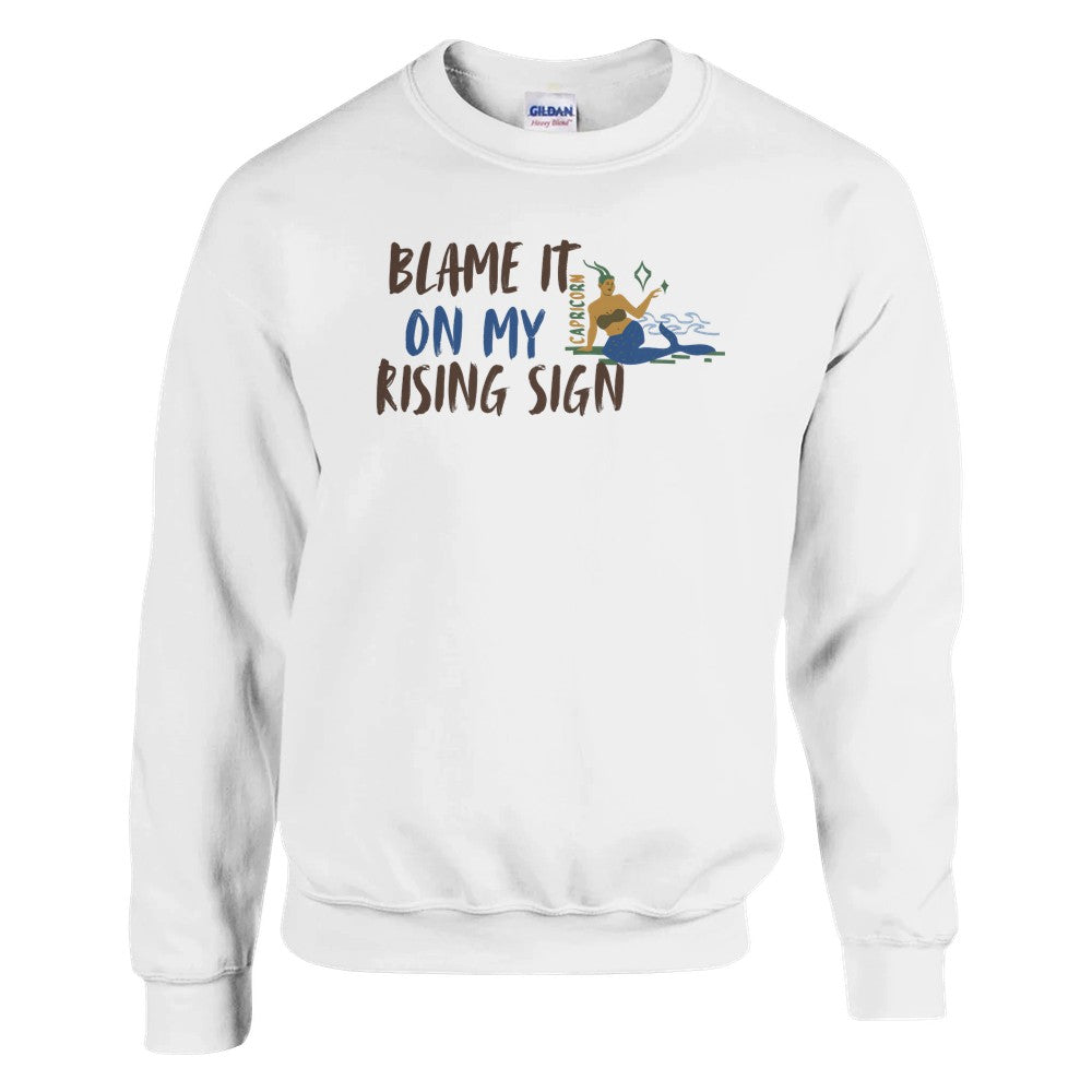 Front of white Capricorn-themed sweatshirt with 'Blame It On My Rising Sign' text and illustration of Capricorn zodiac symbol.