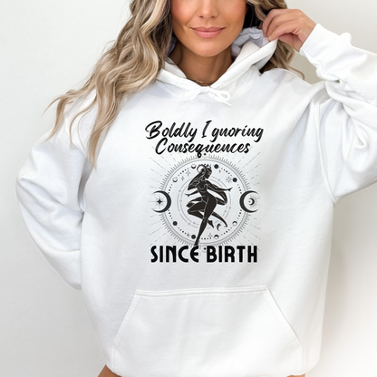 White hoodie with 'Boldly Ignoring Consequences Since Birth' text and celestial illustration.